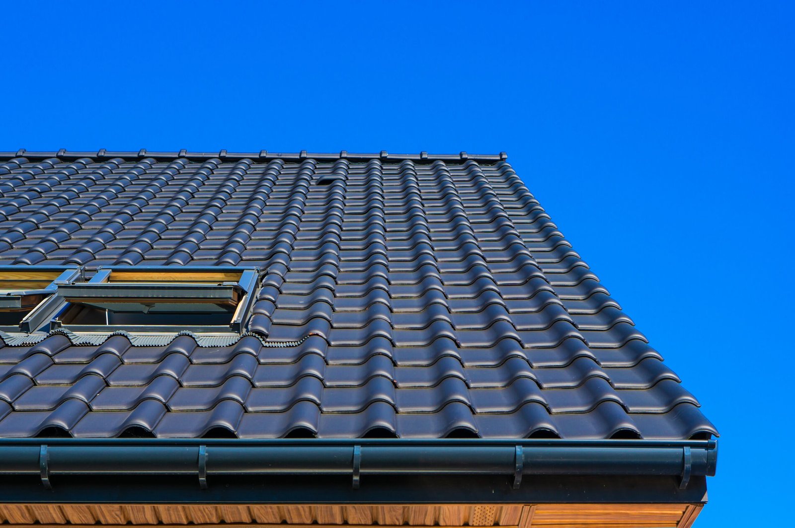 Roofing Services in New York – Expert Installation, Repairs & Maintenance 1 vertical low angle closeup shot black roof building scaled